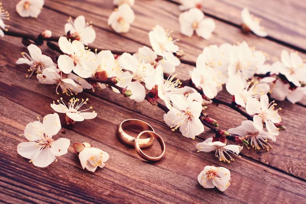 結婚指輪。木製の表面に開花枝花. ロイヤリティフリーのストック写真