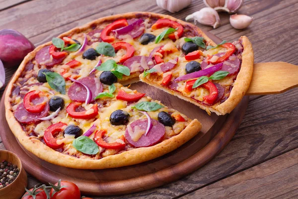 Pizza se šunkou, paprikou a olivami. vynikající čerstvá pizza na dřevěný stůl. — Stock fotografie