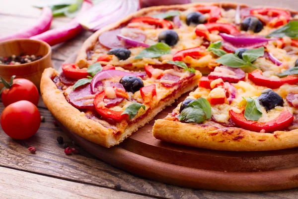 Pizza se šunkou, paprikou a olivami. vynikající čerstvá pizza na dřevěný stůl. — Stock fotografie