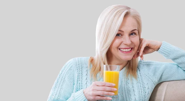 Woman Holds Glass Orange Juice Looks Relaxed Camera Sitting Window — Stock Photo, Image