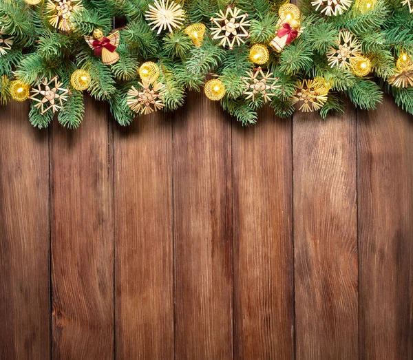 以圣诞树和节日彩灯装饰的带有复制空间的木制背景 图库照片