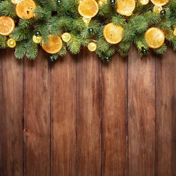 以圣诞树和节日彩灯装饰的带有复制空间的木制背景 免版税图库照片