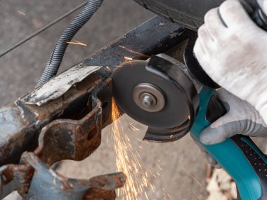 Bir işçinin, bir aksaklıktan çıkan bir parça metali öğütüşünü.