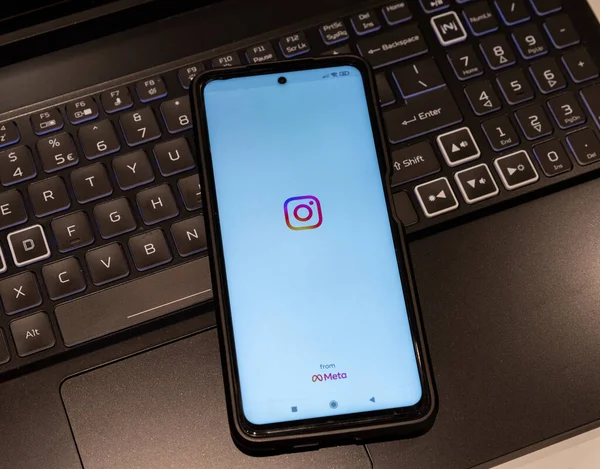 illustration of the instagram logo displayed on a smartphone screen , background is a computer keyboard