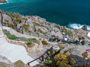 looking down at people walking through minack theatre gardens and carved pathways , cornwall ,  UK ,June 11-2022