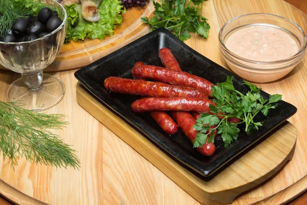 Fried sausages on a wooden background — Stock Photo, Image