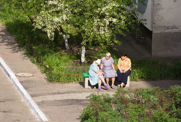 Les vieilles femmes s'assoient sur un banc et parlent . Photos De Stock Libres De Droits