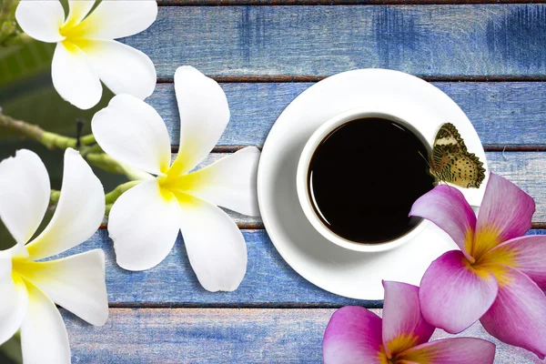 Flower and coffee cup wooden background