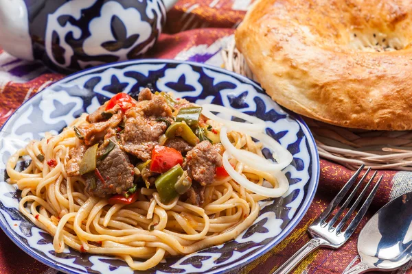 Comida nacional uzbeque em adras de tecido tradicional — Fotografia de Stock