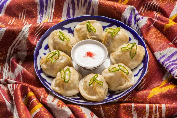 Comida nacional uzbeka en adras de tela tradicional — Foto de Stock