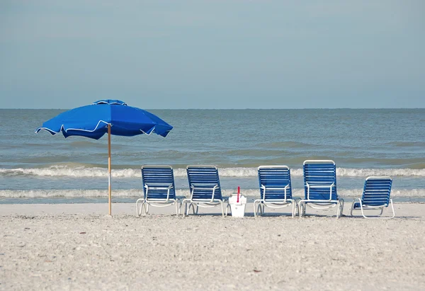 Deserted tropical beach with empty chairs Royalty Free Stock Photos