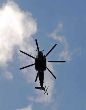 Heavy marine helicopter seen from below against blue sky