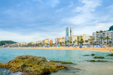 İspanya, Lloret de Mar 'da bulutlu havada kayalıklı kumsal. Dinlenme kavramı.