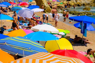 LLORET DE MAR, İSPAN - 29 Temmuz 2019: gezinti güvertesi yakınlarındaki şehir plajında Motley güneş plajı şemsiyeleri. Costa Brava. Plaj istirahatı kavramı. Yaz seyahati.