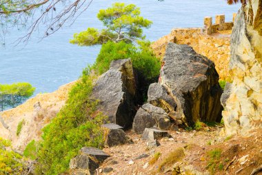 İspanya, Costa Brava, Lloret de Mar 'da bir dağ yamacında kırılmış bir kaya.