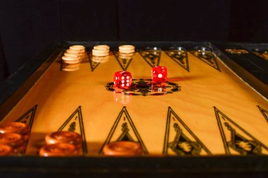 Tavla tahtası. Oyun tahtasında kırmızı şeffaf zarlar.