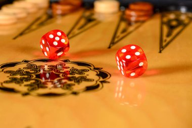 Tavla tahtası. Oyun tahtası üzerinde yuvarlanmış kırmızı şeffaf zarlar.