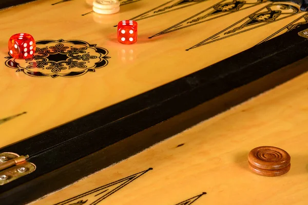 Tahtayla tavla oyunu, parçalar ve kırmızı şeffaf zarlar.