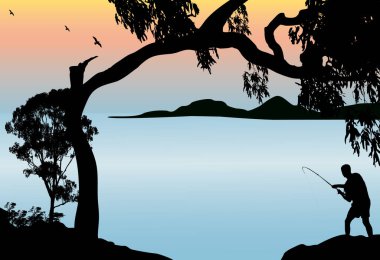 silhouette of a man fishing of the rocks at sunset with large tree and mountains in the background