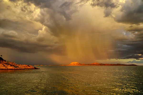 Lake Argyle with stormy clouds and rain falling in the sunset