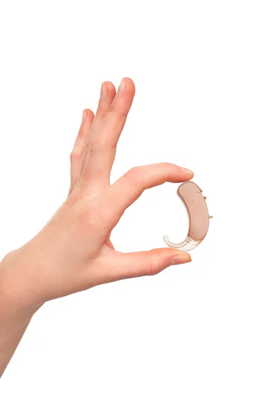 Audífono sin molde de oreja y tubito entre los dedos de la mano femenina joven . —  Fotos de Stock