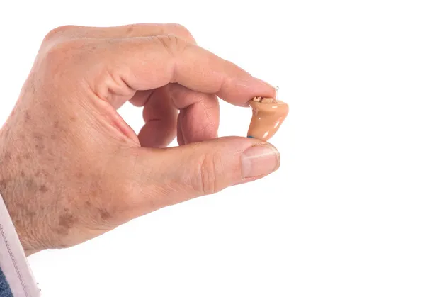 CIC hörapparater mellan fingrar — Stockfoto