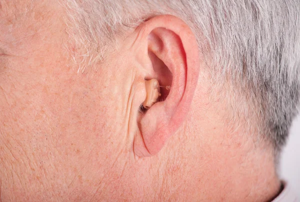 Senior viselése cic hallókészülék Stock Kép