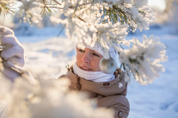 Chica decora un abeto nevado —  Fotos de Stock