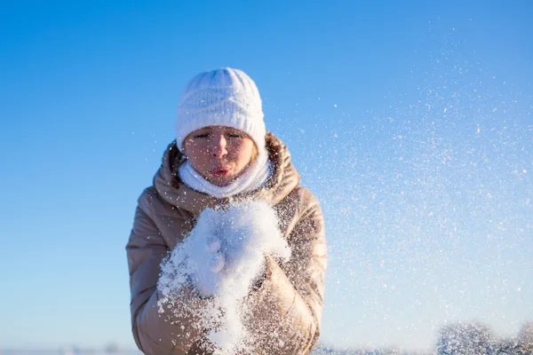 Girl blows away snow off hands — Stock Photo, Image