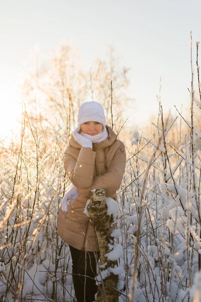 Young girl leaning on a tree in winter — Stock fotografie