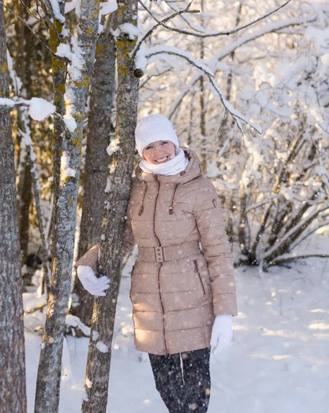 Young girl leaning on a tree snow falls — Stock Photo, Image