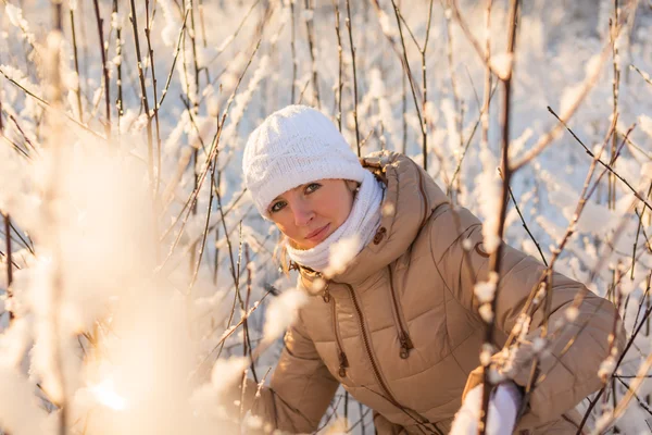 Ung flicka smyger in en vinter skog — Stockfoto