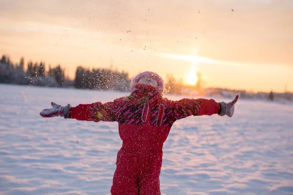 Bambino godendo la neve che cade al sole — Foto Stock