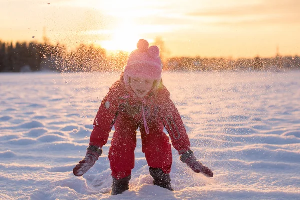 Niño disfrutando de la nieve que cae al sol —  Fotos de Stock