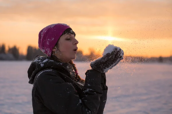 Girl blows snow with hands — Stock Photo, Image