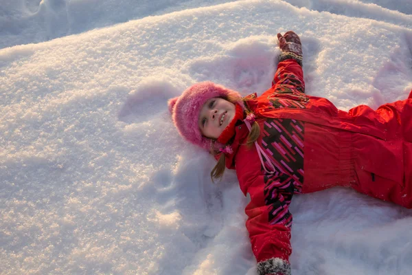 Lilla flickan liggande i snön — Stockfoto