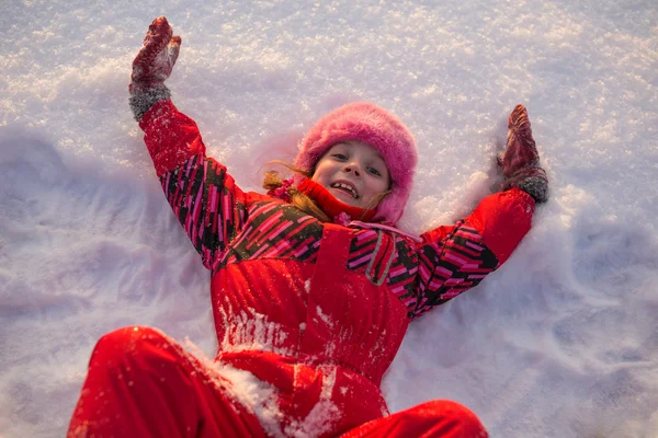 Lilla flickan liggande i snön — Stockfoto