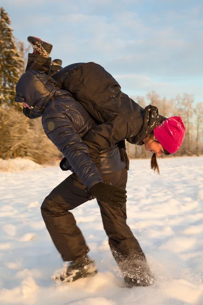 Мужчина с девушкой на плечах зимой — стоковое фото