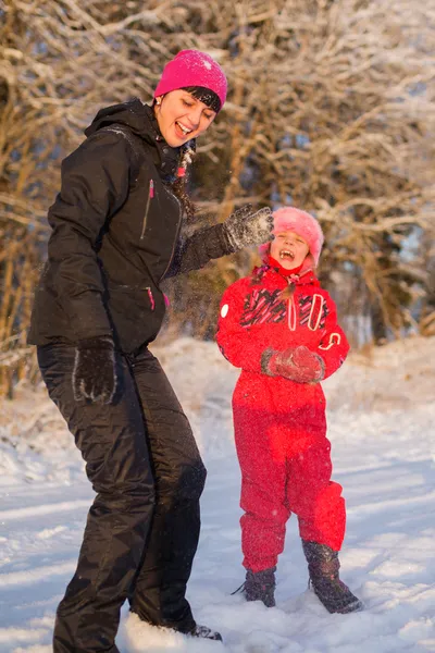 Мама и дочь играют в снежки — стоковое фото