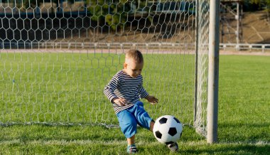 küçük çocuk bir futbol topu tekmeleme