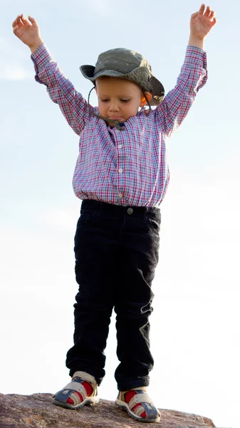 Kleine jongen evenwichtig op een rots — Stockfoto