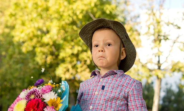 Niño desconcertado con flores —  Fotos de Stock