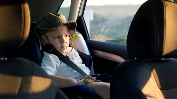 Pequeno menino amarrado em um assento de carro — Fotografia de Stock