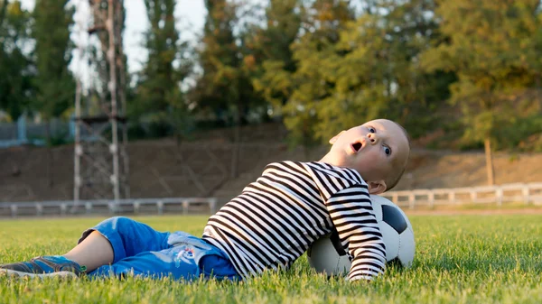 Маленький мальчик играет с футбольным мячом — стоковое фото