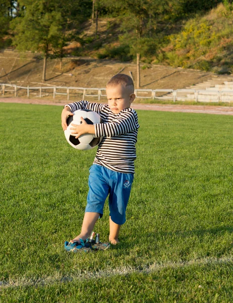 Kleiner Junge hält einen Fußball in der Hand — Stockfoto