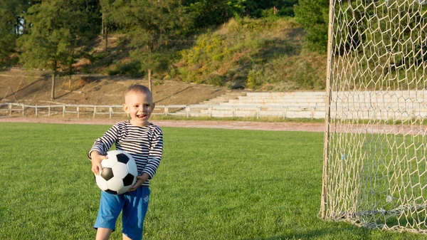 Skrattar liten pojke med boll — Stockfoto