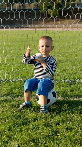 Petit garçon frappant un ballon de football — Photo