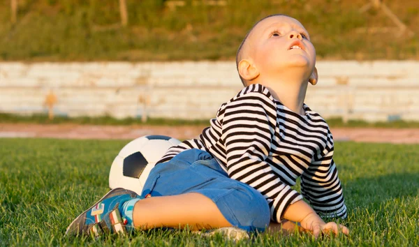 Liten pojke sparka en fotboll — Stockfoto