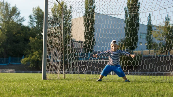 Kleiner Junge, der einen Fußball kickt — Stockfoto