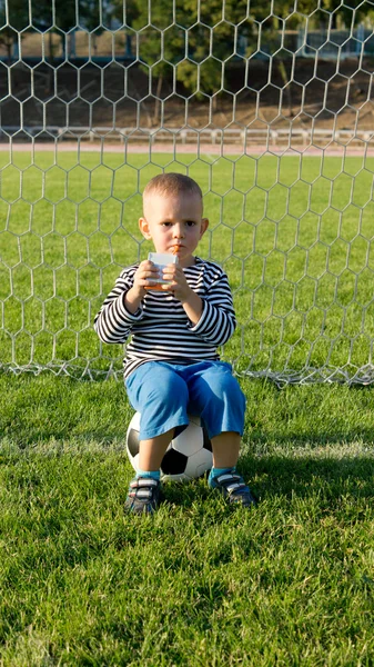 Piccolo ragazzo calci un pallone da calcio — Foto Stock